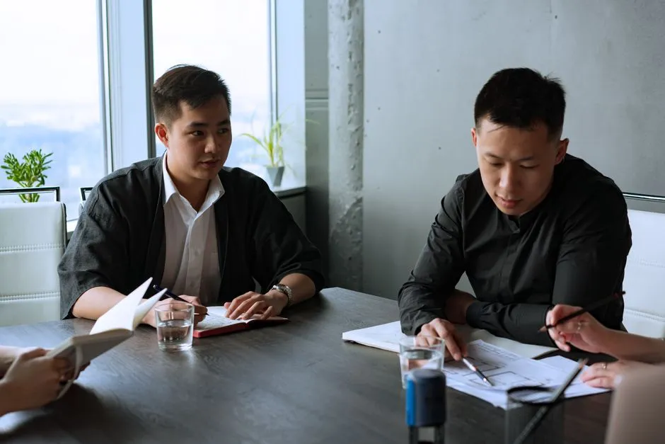 Group of Asian professionals having a meeting in a modern office setting.